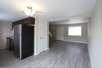 Image of large room with vinyl plank flooring and ceiling fan